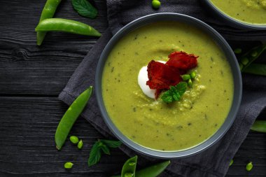 Tatlı bezelye, pırasa ve nane sıcak çorba gevrek domuz pastırması ve dolop yoğurt ile tepesinde