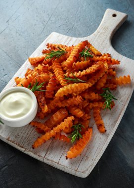 Pişmiş Balkabagi deniz tuzu ve biberiye ile patates kızartması. Beyaz ahşap tahta üzerinde kabak cips.