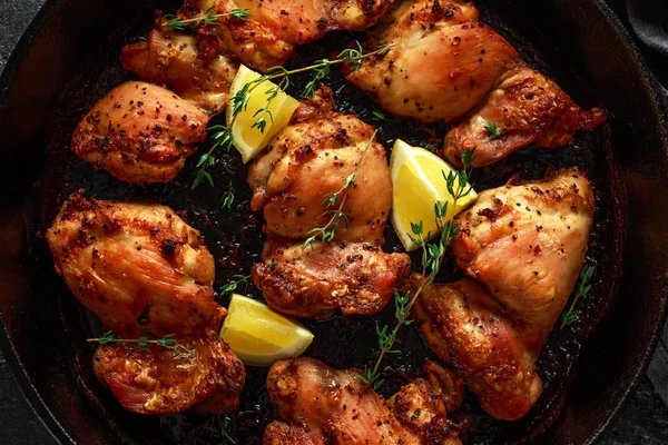 Roasted boneless skinless chicken thighs in lemon and thyme dressing served in vintage cast iron skillet, frying pan — Stock Photo, Image