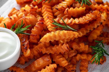 Pişmiş Balkabagi deniz tuzu ve biberiye ile patates kızartması. Beyaz ahşap tahta üzerinde kabak cips.