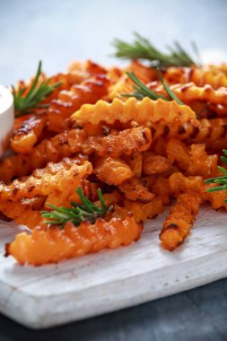 Pişmiş Balkabagi deniz tuzu ve biberiye ile patates kızartması. Beyaz ahşap tahta üzerinde kabak cips.