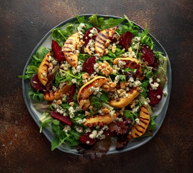 Pişmiş ve taze rendelenmiş pancar, mavi peynir, ceviz rustik masa üzerinde ızgara ayva salatası