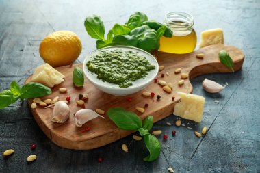 Yeşil fesleğen Pesto parmesan peyniri, çam fıstığı, sarımsak ve limon ahşap tahta üzerinde