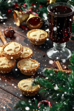 İngiliz Noel kıymalı börek dekorasyon, hediyeler, kar, ahşap rustik masa üzerinde yeşil ağaç dalı ile