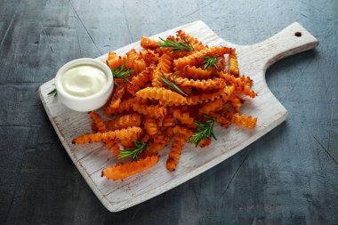 Pişmiş Balkabagi deniz tuzu ve biberiye ile patates kızartması. Beyaz ahşap tahta üzerinde kabak cips.