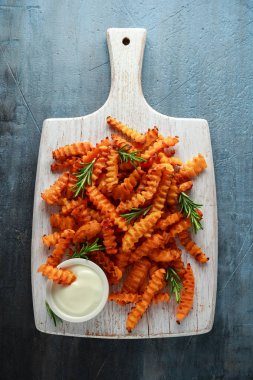 Pişmiş Balkabagi deniz tuzu ve biberiye ile patates kızartması. Beyaz ahşap tahta üzerinde kabak cips.