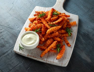 Pişmiş Balkabagi deniz tuzu ve biberiye ile patates kızartması. Beyaz ahşap tahta üzerinde kabak cips.