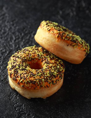 Turuncu Donut ile sprinkles rustik koyu arka plan üzerinde