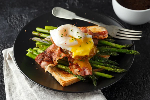 Bento escalfou o ovo do pato com bacon crocante e espargos fritos em torradas para o café da manhã — Fotografia de Stock
