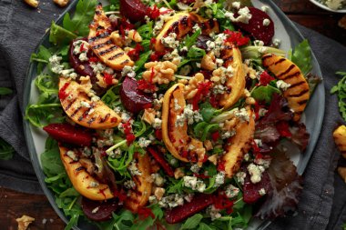 Pişmiş ve taze rendelenmiş pancar, mavi peynir, ceviz ahşap rustik masa üzerinde ızgara ayva salatası