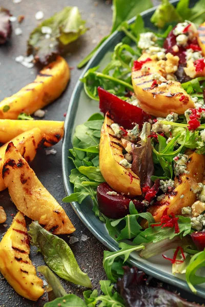 Pişmiş ve taze rendelenmiş pancar, mavi peynir, ceviz rustik masa üzerinde ızgara ayva salatası