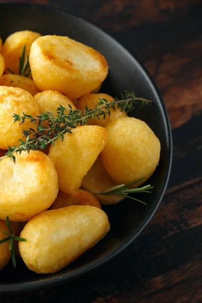 Tuz, sarımsak, biberiye ve kekik rustik ahşap zemin üzerine altın kızartma patates terbiyeli