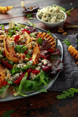 Pişmiş ve taze rendelenmiş pancar, mavi peynir, ceviz ahşap rustik masa üzerinde ızgara ayva salatası