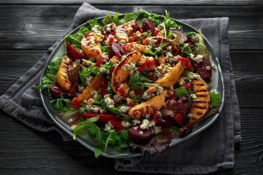 Pişmiş ve taze rendelenmiş pancar, mavi peynir, ceviz ahşap rustik koyu masa üzerinde ızgara ayva salatası