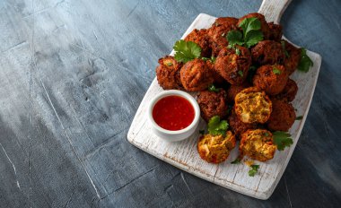 Hint Pakora Aperatif baharatlı soğan, kırmızı biber biber soslu Beyaz ahşap tahta üzerinde