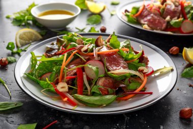 Havuç, turp, fasulye filizi, biber, fındık ve yeşil karışımı ile baharatlı biftek salatası