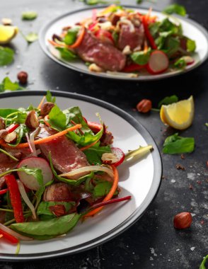 Havuç, turp, fasulye filizi, biber, fındık ve yeşil karışımı ile baharatlı biftek salatası