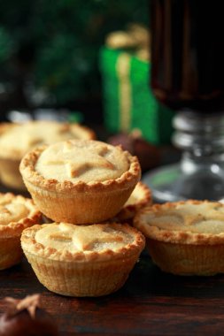 İngiliz Noel kıymalı börek dekorasyon, hediyeler, ahşap rustik masa üzerinde yeşil ağaç dalı ile