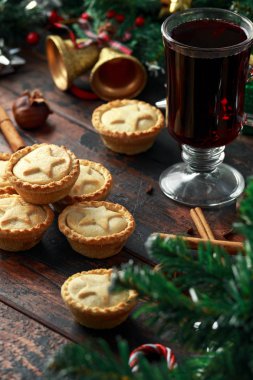 İngiliz Noel kıymalı börek dekorasyon, hediyeler, ahşap rustik masa üzerinde yeşil ağaç dalı ile