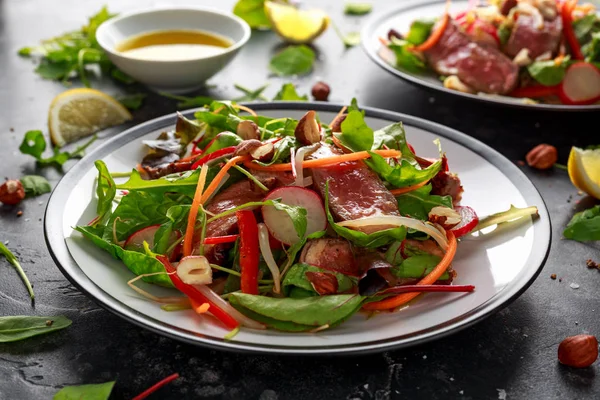 Havuç, turp, fasulye filizi, biber, fındık ve yeşil karışımı ile baharatlı biftek salatası