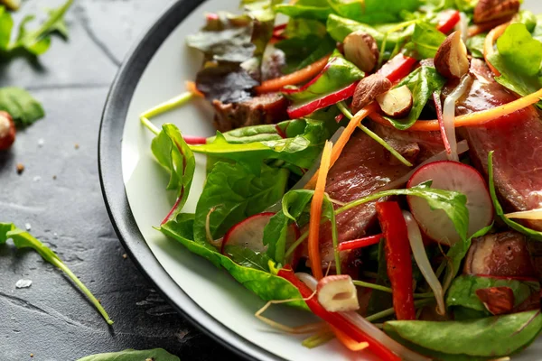 Salada de carne picante com cenoura, rabanete, brotos de feijão, pimenta, nozes e mistura verde — Fotografia de Stock