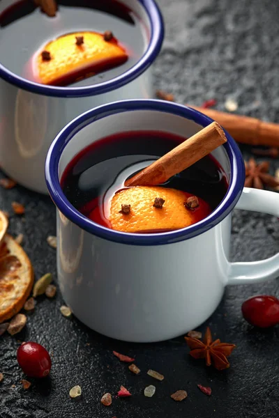 Vin chaud dans des tasses rustiques blanches aux épices et fruits à l'orange — Photo