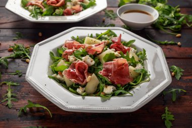Mozzarella peyniri, roka ve çam fıstığı ile Parma ham ve kavun salatası.
