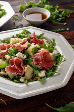 Mozzarella peyniri, roka ve çam fıstığı ile Parma ham ve kavun salatası