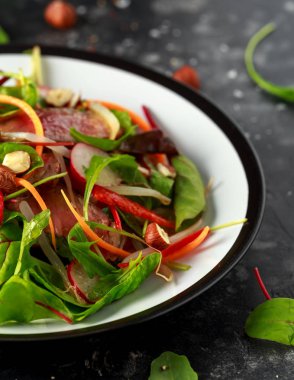 Havuç, turp, fasulye filizi, biber, fındık ve yeşil karışımı ile baharatlı biftek salatası