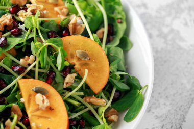 Lezzetli Trabzon hurması ve bezelye salatası ceviz, nar ve kabak çekirdeği ateş.