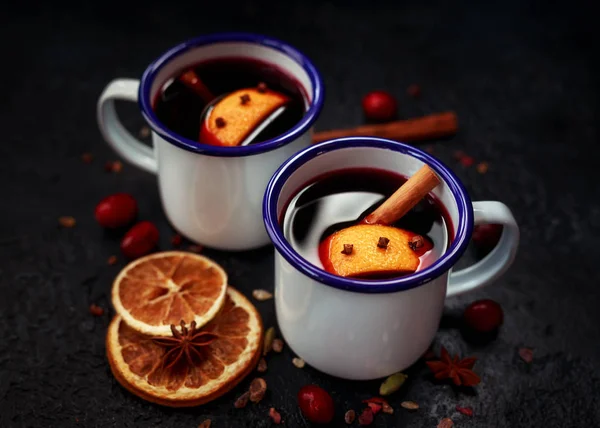 Vinho amontoado em canecas brancas rústicas com especiarias e frutas de laranja — Fotografia de Stock