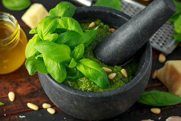 Green Basil Pesto em argamassa de mármore com queijo parmesão, pinhões, alho e limão . — Fotografia de Stock