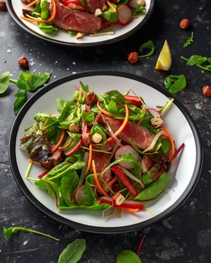 Havuç, turp, fasulye filizi, biber, fındık ve yeşil karışımı ile baharatlı biftek salatası