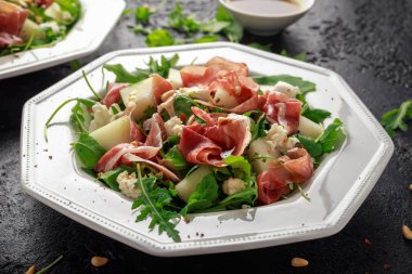 Mozzarella peyniri, roka ve çam fıstığı ile Parma ham ve kavun salatası