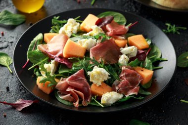 Parma salata mozzarella peyniri ile jambon ve kavun, yeşil yaprakları karışımı