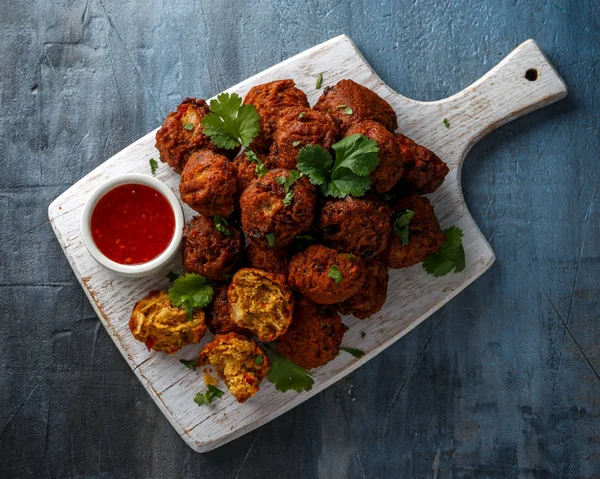 Indian Pakora lanche cebola picante, pimenta vermelha com molho de pimenta na tábua de madeira branca — Fotografia de Stock