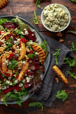 Pişmiş ve taze rendelenmiş pancar, mavi peynir, ceviz ahşap rustik masa üzerinde ızgara ayva salatası