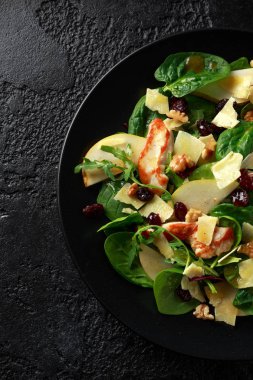 Armut, kaşar peyniri, kızılcık ve ceviz tavuk salatası. sağlıklı gıda. siyah taş zemin