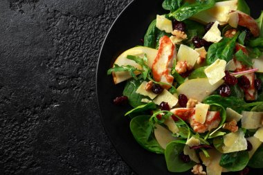 Armut, kaşar peyniri, kızılcık ve ceviz tavuk salatası. sağlıklı gıda. siyah taş zemin