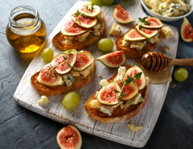 Bu Gorgonzola ve incir tartines, tost, bruschetta. Beyaz ahşap tahta üzerinde bal ile drizzled