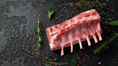 raw fresh rack of lamb with green herbs. clipart