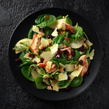 Armut, kaşar peyniri, kızılcık ve ceviz tavuk salatası. sağlıklı gıda. siyah taş zemin