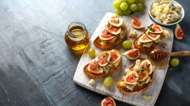 Bu Gorgonzola ve incir tartines, tost, bruschetta. Beyaz ahşap tahta üzerinde bal ile drizzled