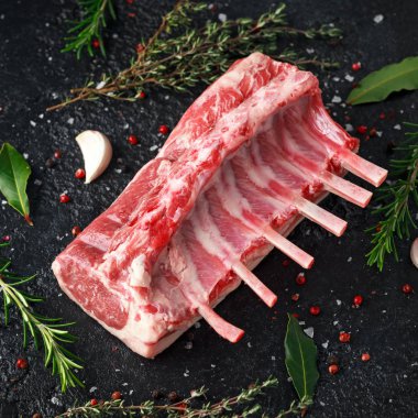 raw fresh rack of lamb with green herbs. clipart