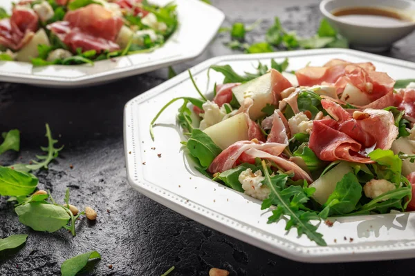 Mozzarella peyniri, roka ve çam fıstığı ile Parma ham ve kavun salatası.
