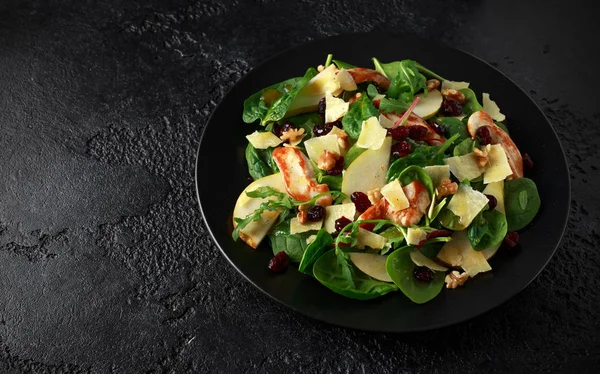 Armut, kaşar peyniri, kızılcık ve ceviz tavuk salatası. sağlıklı gıda. siyah taş zemin