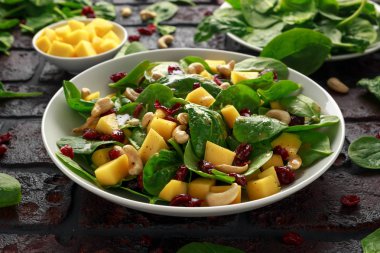 Kurutulmuş cranberries ve fındık ile Mango ıspanak salatası. sağlıklı gıda.
