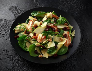 Armut, kaşar peyniri, kızılcık ve ceviz tavuk salatası. sağlıklı gıda. siyah taş zemin