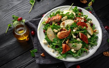 Armut, mavi peynir, kızılcık ve ceviz tavuk salatası. kavram sağlıklı gıda. siyah arka plan