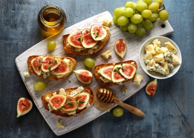 Bu Gorgonzola ve incir tartines, tost, bruschetta. Beyaz ahşap tahta üzerinde bal ile drizzled